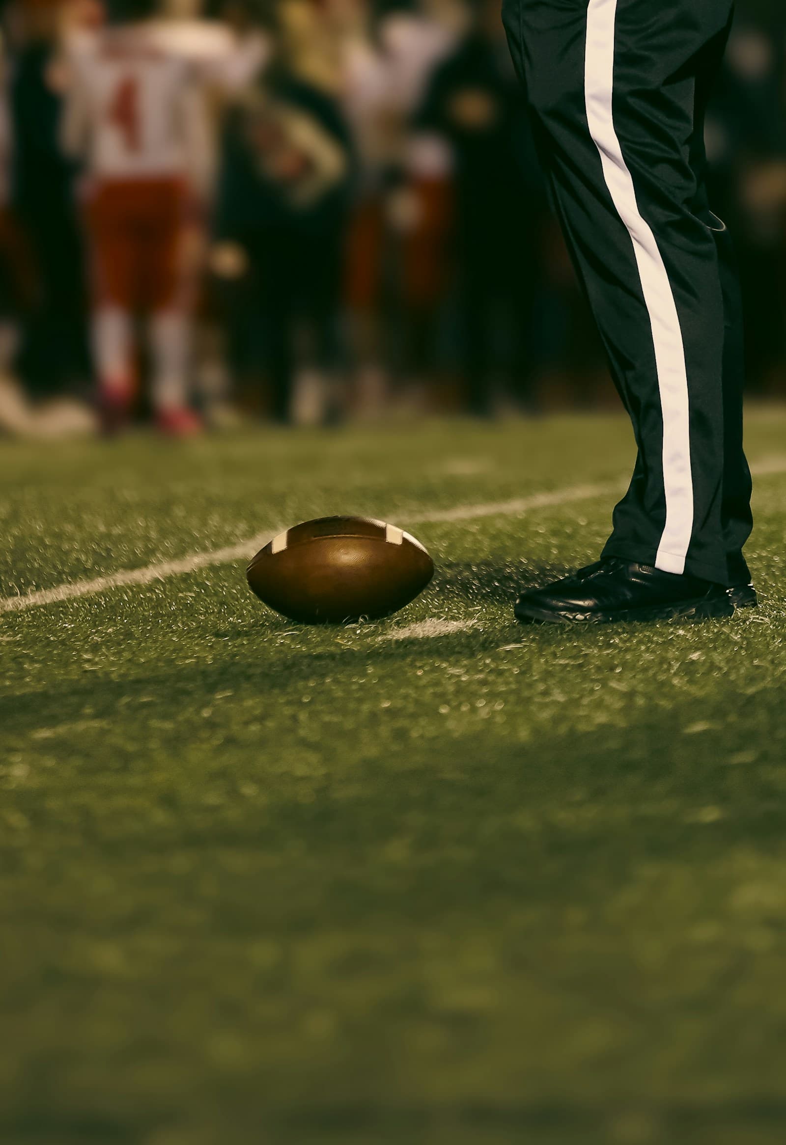 American football on the field under stadium lights